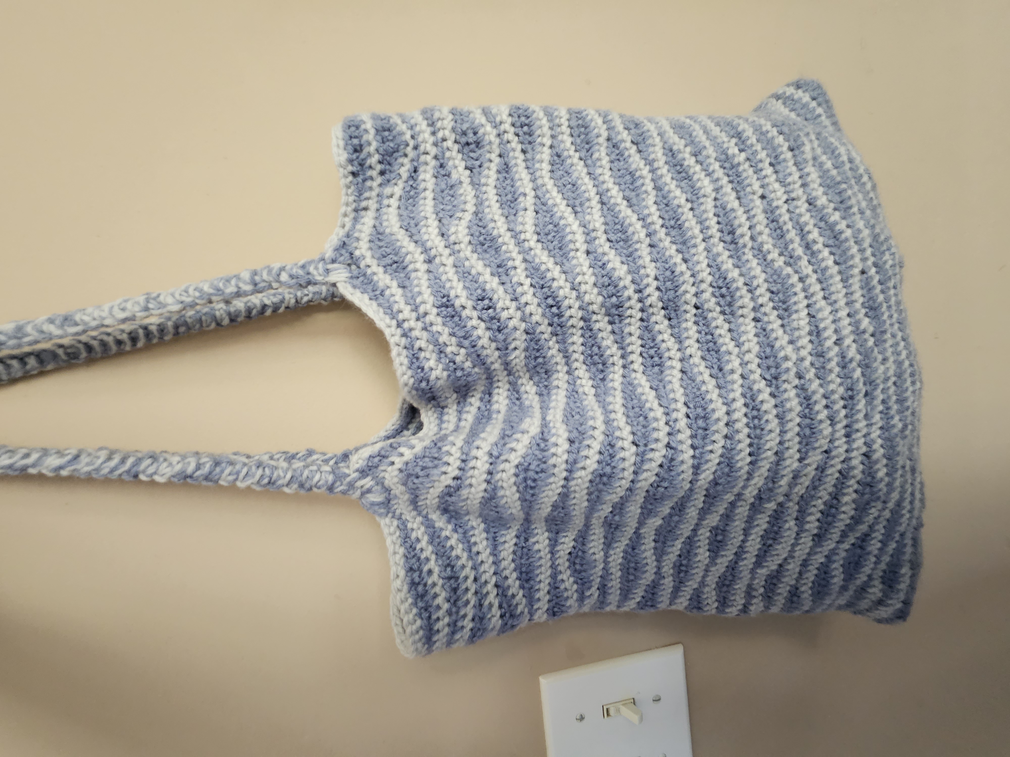 A finished wave-stitch shoulder bag with a soft, everyday shape.
